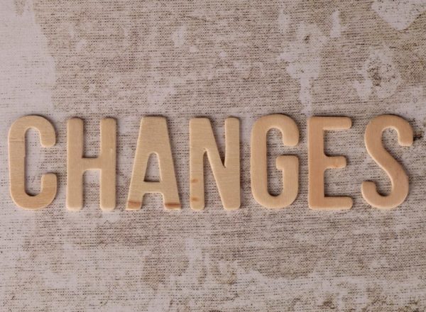 Wooden letters arranged to form 'Changes' on a textured, rustic surface.