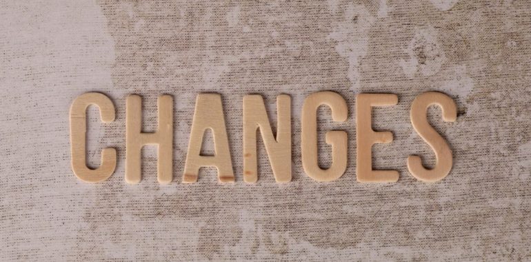 Wooden letters arranged to form 'Changes' on a textured, rustic surface.